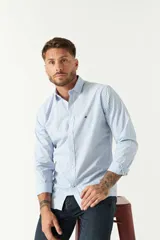 Camisa celeste a cuadros, de corte slim fit, manga larga y logo bordado. Confeccionada en 100% algodón.