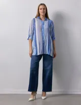 Camisa larga de rayón marca Robert Louis, con estampado a rayas verticales en tonos coral y blanco. Tiene cuello con solapa, abertura central con botones, mangas largas regulables con presilla y botón, y tajos laterales.