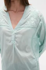 Blusa de algodón color menta, con escote en V, mangas largas y detalles de bordado floral y mostacillas en los hombros y el escote.