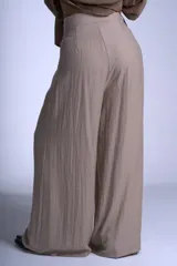 Pantalón de vestir color beige, de corte sastrero con tablas frontales y cintura con lazo.