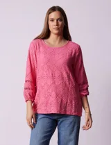 Blusa de broderie color blanco, de mangas largas con puños elásticos.