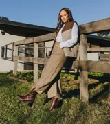 Bota corta color crema con textura de reptil, caña media, punta cuadrada, cierre lateral y taco de madera.