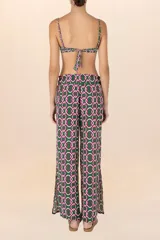 Pantalón largo de corte palazzo, con cintura elástica y estampado de cadenas entrelazadas en tonos verde oscuro, blanco y fucsia.