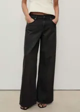 Pantalón de jean negro de corte wide leg, tiro bajo y cinco bolsillos.