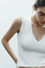 Camiseta negra de corte ajustado (slim fit) con escote pico pronunciado y manga sisa.