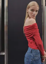 Blusa roja con hombros descubiertos y mangas largas.