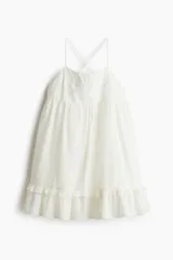 Vestido corto blanco de algodón con breteles finos cruzados en la espalda, escote cuadrado, bordado en el busto y falda con volados.