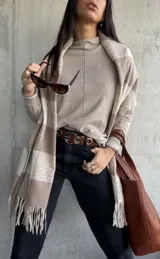 Sweater beige de cuello alto, corte holgado y mangas largas.