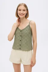 Musculosa color verde oliva con bordado calado, breteles finos y escote en V con volados.