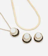 Conjunto de collar y aros dorados con colgantes circulares esmaltados en blanco y negro. El collar es de cadena de eslabones pequeños y los aros son tipo botón.