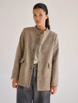 Chaqueta de lana color marrón con diseño de espiga, cuello mao, cierre frontal con botones dorados, bolsillos de parche y corte recto.