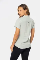 Camisa de lino color salmón, de corte clásico, con cuello camisero, medio abotonada, de manga corta y con dos bolsillos frontales con solapa.