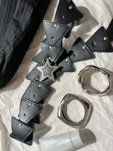 Cinturón negro de cuero sintético con apliques triangulares y hebilla de estrella plateada.