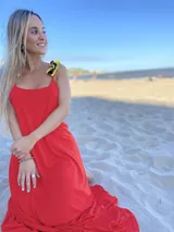 Vestido largo color rojo con breteles amarillos y escote en la espalda.