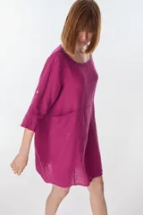 Vestido color fucsia de lino italiano, con cuello redondo, moldería oversize y bolsillos delanteros.