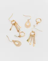 Set de tres pares de aros dorados con diferentes diseños: argollas pequeñas con dije de perla, aros colgantes con forma de lágrima calada y aros colgantes con círculo y flecos.