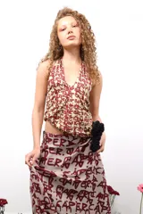 Top halter estampado con letras en color borgoña sobre fondo verde claro.