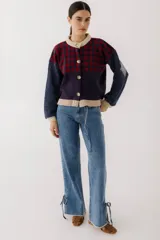 Cárdigan marrón con diseño de rombos en tonos rojizos y beige. Tiene cuello redondo, cierre frontal con botones y mangas largas con puños acanalados.