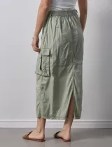 Falda larga color beige, de corte recto, con bolsillos cargo laterales y traseros, pretina con pasadores, botón y cierre.