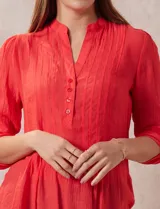 Blusa blanca de gasa bambula, marca Zac & Rachel. Cuello a la base, escote en V con apertura y botones. Largo de manga regulable con presilla y botón.