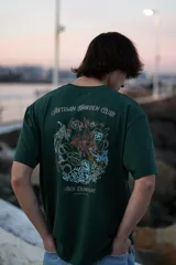 Camiseta verde oscuro de manga corta y cuello redondo con estampado de flores y texto en la espalda.