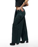 Pantalón de denim verde inglés con corte sastrero de pierna ancha, tiro alto y pretina cruzada.