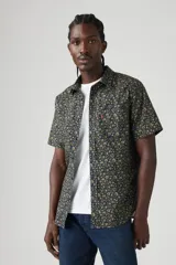 Camisa de manga corta con estampado floral en tonos azul, verde y amarillo. Tiene cuello clásico, cierre con botones y un bolsillo en el pecho.