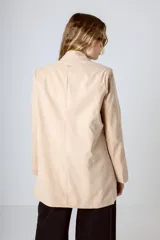Blazer color beige con doble botonadura, solapas de muesca y corte holgado.