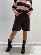 Bermuda marrón de gabardina elastizada con cinturón fino con tachas y detalles de flecos en el ruedo.