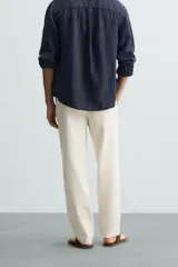 Pantalón verde oscuro de algodón con textura, corte recto, cintura elástica ajustable con cordón, bolsillos laterales y traseros de vivo.