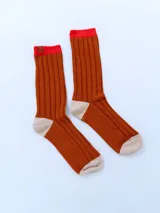 Par de medias acanaladas color ladrillo con puntera y talón en color crema y puño superior en color rojo.