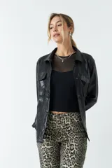 Sobrecamisa color beige de efecto cuero, con cuello clásico, cierre frontal con botones a tono, mangas largas con puños abotonados, dos bolsillos con solapa en el pecho y corte recto.