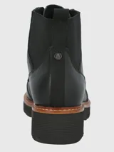 Bota corta de mujer color negro, estilo militar o acordonado, con caña media y elástico en el tobillo. Presenta suela track gruesa con plataforma y un ribete marrón contrastante entre la capellada y la suela.