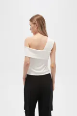 Top negro de poliéster, al cuerpo y con cuello asimétrico.