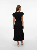 Vestido midi negro de tejido plano, con escote en V con cordones ajustables y mangas cortas con detalle de calado o puntilla. Presenta un lazo para ajustar a la cintura y falda con corte en capas que termina en un ruedo con volado.