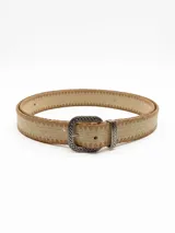 Cinto de vestir color beige con hebilla metálica plateada con diseño labrado.