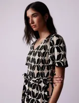 Vestido estampado con escote en V con frunces, cintura elastizada con lazo de ajuste y mangas cortas con detalles en broderie.