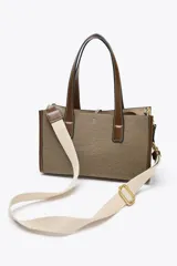 Bolso tipo shopper color marrón con doble asa corta y correa larga extraíble. Tiene detalle de pespuntes y anilla metálica decorativa. Incluye bolsa de tela interior extraíble con cierre fruncido.