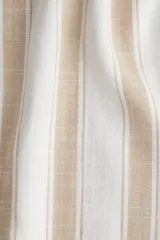 Pantalón de lino color crudo con rayas verticales color beige. Corte holgado, cintura elástica con cordón ajustable y piernas anchas extralargas.