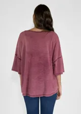 Remera color amarillo con cuello redondo y mangas cortas amplias, con detalle de botones en los laterales.