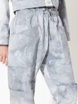 Pantalón tipo babucha gris con cintura elastizada, lazo ajustable y bolsillos cargo.