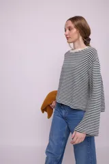 Remera de mangas largas a rayas horizontales verdes y blancas, de corte amplio y cuello redondo.
