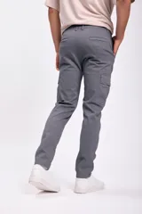 Pantalón cargo gris oscuro con múltiples bolsillos laterales y corte ajustado.