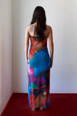 Vestido strapless ajustado al cuerpo, con estampado abstracto multicolor en tonos naranja, negro, fucsia, verde, azul y rojo.