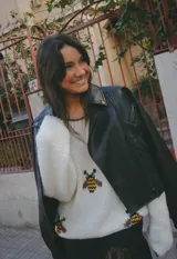 Sweater tejido a mano en lana merino color crudo, con cuello redondo y diseño de abejas bordadas en el frente.