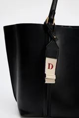 Bolso negro tipo shopper con asa de hombro, detalle de colgador y bolsillo interior maxi. Cierre mediante imán.