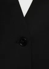 Chaleco negro con cuello halter, espalda descubierta y cierre frontal con botones.