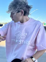 Remera celeste de corte holgado con cuello redondo y estampado en relieve con el logo de la marca y la frase "Ittai Stars".