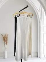 Pollera larga de satén color blanco con pequeños brillos.