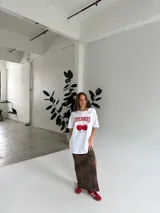 Remeron de algodón blanco con gráfico de cerezas y texto colorido, de corte suelto y cómodo.